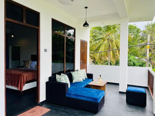 a living room with a blue couch and a bed at ANB Surf View in Tangalle