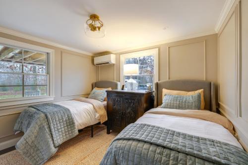 a bedroom with two beds and a desk and windows at Summer Beach Pass: Wooded Martha's Vineyard Escape in Vineyard Haven