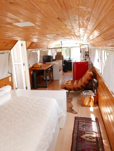 a bedroom with a bed and a desk in a van at Refúgio Veadeiros Ônibus in Sao Jorge