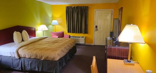 a hotel room with a bed and a table and lamp at LACENTER MOTEL in La Center