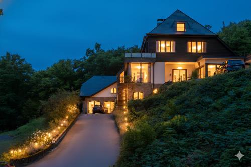 a house with lights on the side of a road at Homestorys Nature Resort - Wood Lounge in Eupen