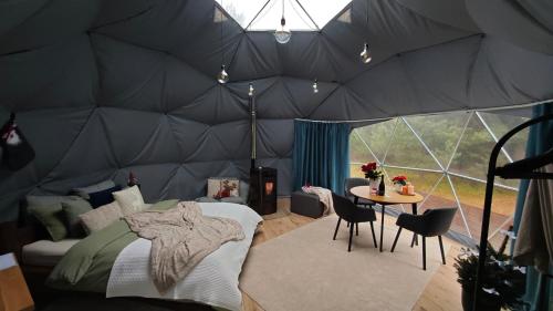 a bedroom in a tent with a bed and a table at Merekalda Glämp in Moldova