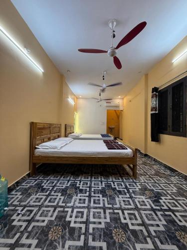 a bedroom with a bed and a ceiling fan at GYANi 1 in Tiruvannāmalai