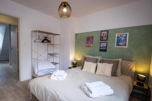a bedroom with a large bed with towels on it at Hesdin Appart Holidays 2 in Hesdin