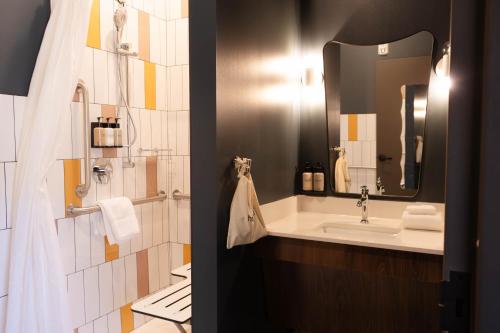 a bathroom with a sink and a mirror at Hotel Alexander in Mankato