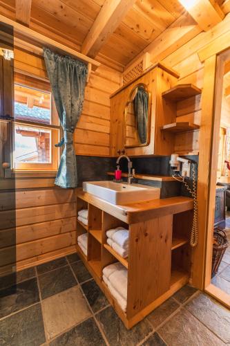 a kitchen with a sink in a wooden cabin at Schlosswirt Chalets & Apartments in Großkirchheim