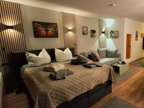 a bedroom with a large bed and a couch at Apartment Wohlfühl-Oase mit Pool & Sauna, aktivCard inkl in Sankt Englmar