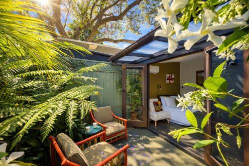 a backyard patio with chairs and a bed and trees at Balmain Village Retreat AC Free Street Parking City 3km in Sydney