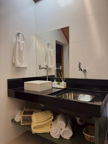 a bathroom with a sink and a mirror and towels at Loft Itália in Santa Teresa