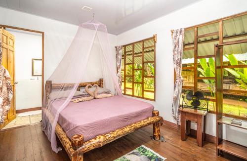 a bedroom with a bed with a mosquito net at Playa Ganadito Ecolodge in Drake
