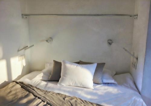 a bed with white pillows on it in a room at Can Joseph I Can Toni Platera in Sant Francesc Xavier
