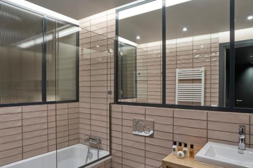 a bathroom with a tub and a sink and a mirror at Elounda Olivia Luxury Villa Spinalonga View in Elounda