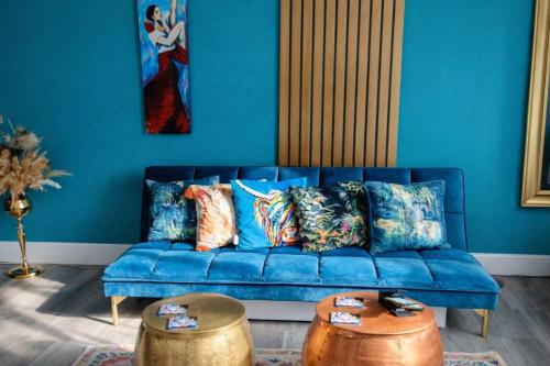 a blue couch with pillows in a living room at Luxury ApArt Gallery Apartment 1 Near River & Free Parking in Bedford