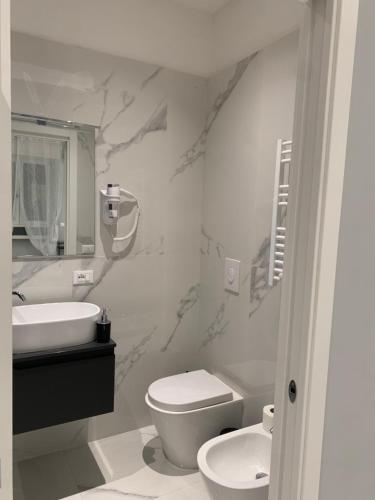 a white bathroom with a toilet and a sink at Al Barone 37 in Foggia