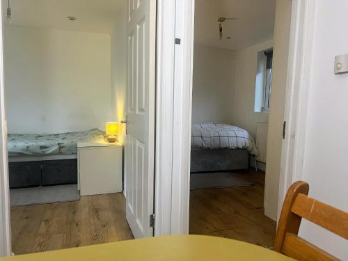 a bedroom with a bed and a table in a room at Compact single room A near Heathrow with 24 hour buses to all terminals in Feltham