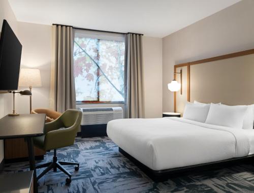 a hotel room with a bed and a desk and a window at TownePlace Suites by Marriott Corbin in Corbin