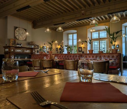 a restaurant with a wooden table and chairs and a clock at Le Château de La Pomarède in La Pomarède
