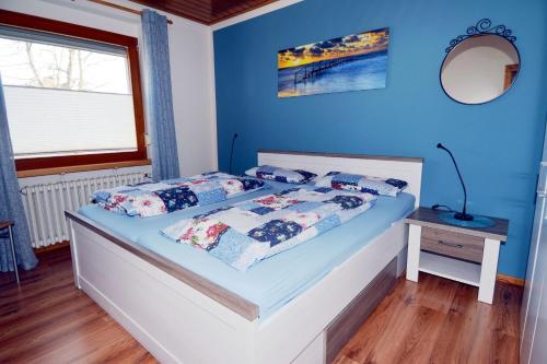 a bedroom with a bed with blue walls at Windstill - Wendstrasse 16 in Heiligenhafen