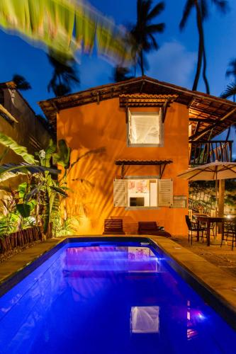 a swimming pool in front of a house at Vila Charme in Jericoacoara
