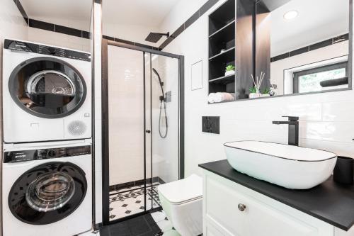 a bathroom with a washing machine and a sink at Horský apartmán Kuba in Bedřichov