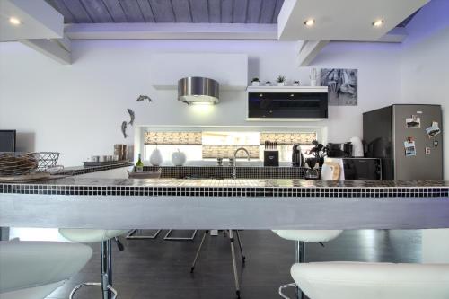 a kitchen with a counter with stools and a sink at Charming villa Darte with private pool near Rovinj, extra pool heating available in Kanfanar