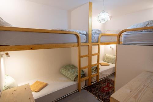 a room with three bunk beds and a table at Surf House Desert Point in Agadir