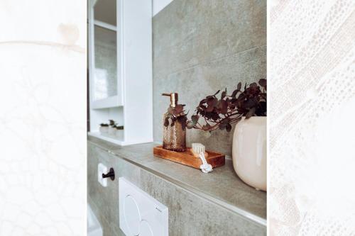 a bathroom with a vase and a plant on a shelf at Käferhain, App 135 in Groitzsch