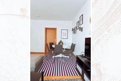 a living room with white walls and a table and chairs at Käferhain, App 134 in Groitzsch