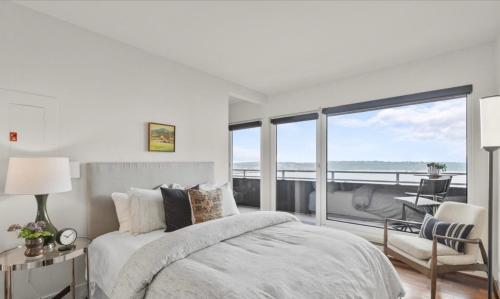 a bedroom with a bed and a view of the ocean at Luxury, ocean view Condo with deck and indoor pool in Seattle
