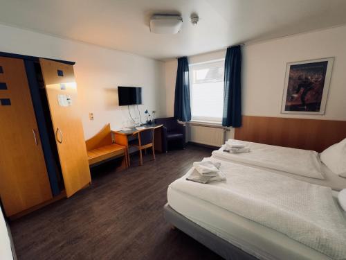 a hotel room with a bed and a desk at Pension Werre Stern self check-in ,nähe Werre Park in Bad Oeynhausen