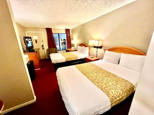 a hotel room with two beds and a television at Rodeway Inn Jackson Northwest in Jackson
