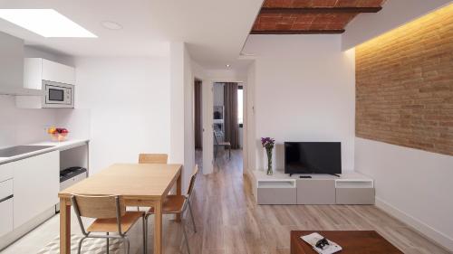 eine Küche und ein Esszimmer mit einem Tisch und einem TV in der Unterkunft Hotel Sagrada Familia Apartments in Barcelona