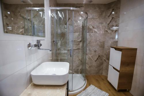 a bathroom with a shower with a toilet and a sink at Hotel Lubaczów Hotel Restauracja u Dina in Lubaczów