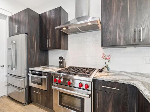 a kitchen with stainless steel appliances and wooden cabinets at CaSEAta by 30A Escapes in Rosemary Beach