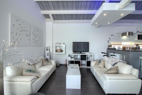 a living room with two white couches and a table at Charming villa Darte with private pool near Rovinj, extra pool heating available in Kanfanar