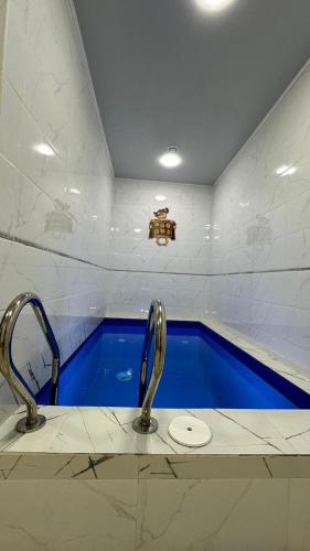 a bathroom with two faucets and a swimming pool at Klass in Taraz