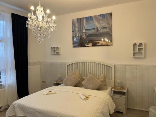 a bedroom with a bed and a chandelier at NordseeNest Varel in Varel