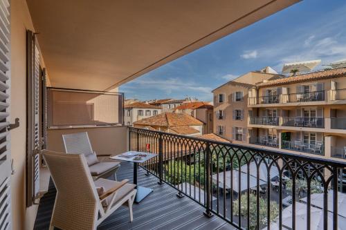 a balcony with two chairs and a table at Hôtel de Paris Saint-Tropez in Saint-Tropez