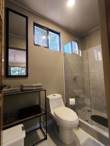 a bathroom with a toilet and a shower at Tekana Boutique Hotel Jungle Retreat in Tamarindo