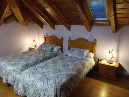 a bedroom with two beds and two lamps on tables at La Artesana in Posada de Rengos