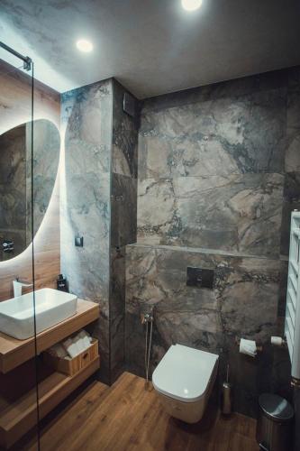 a bathroom with a sink and a toilet at Persey Flora Apartments in Borovets