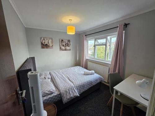 a small bedroom with a bed and a window at Fenia Estate in Barking