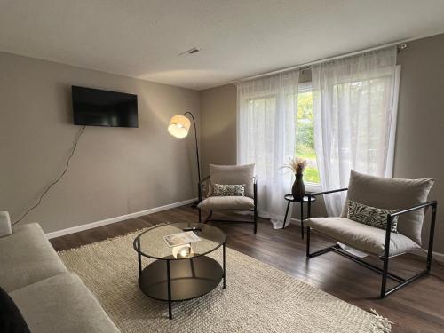 a living room with a couch and chairs and a tv at Horace House Retreat in Saint Paul