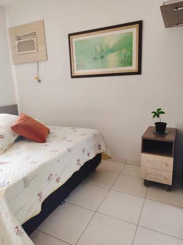 a bedroom with a bed and a picture on the wall at Apartamento Completo I Suíte Casal in Guarapari