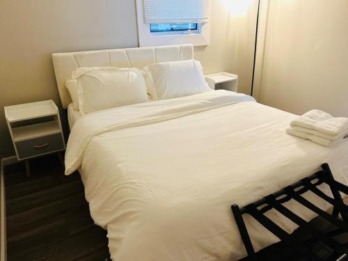 a large white bed with white sheets and pillows at Horace House Retreat in Saint Paul