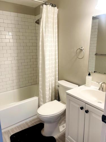 a white bathroom with a toilet and a sink at Horace House Retreat in Saint Paul