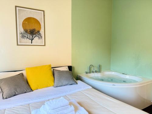 a bathroom with a tub and a bed in a room at Luxury Studio con Private Jacuzzi, Spa Experience in Perugia