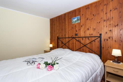 a bedroom with a white bed with flowers on it at Casa di Maen in Valtournenche