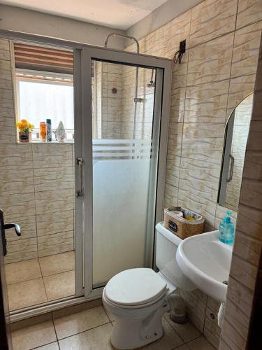 a bathroom with a shower and a toilet and a sink at Comfy cozy in Kira