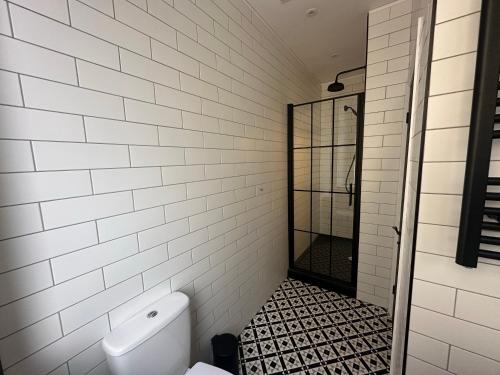 a white tiled bathroom with a toilet and a shower at Akroyd House - The Mackintosh Room in Halifax